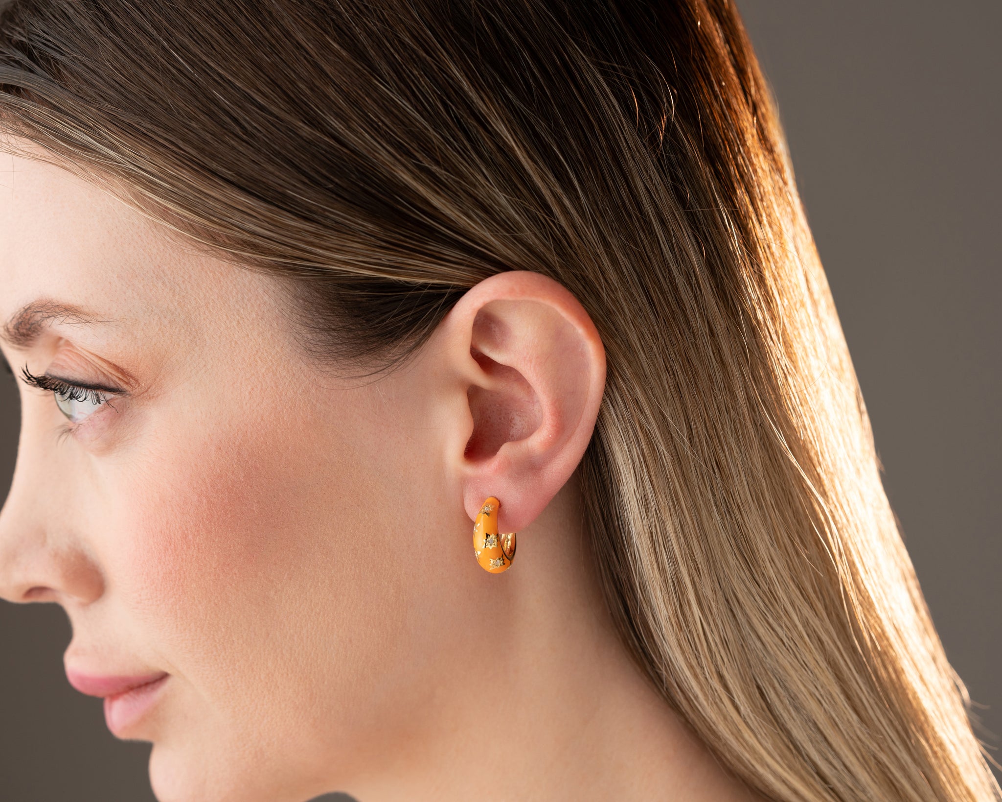 A model wearing celestial statement hoop earrings, styled with boho-chic fashion.