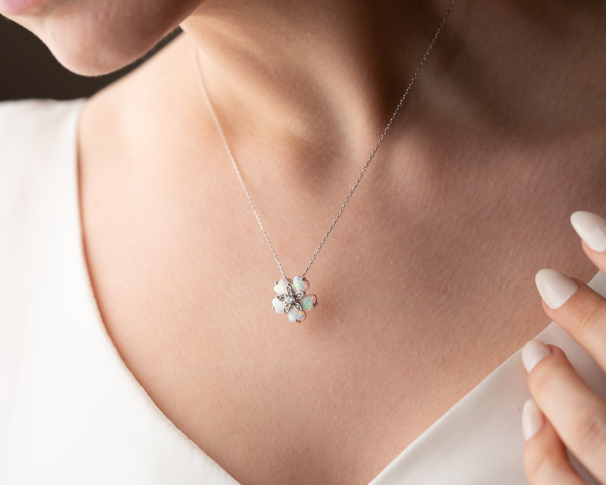 A timeless sterling silver flower necklace with a glowing opal gemstone, symbolizing grace and femininity.